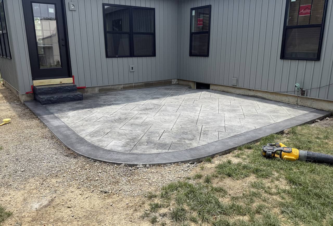 Stamped concrete patio with curved dark gray border